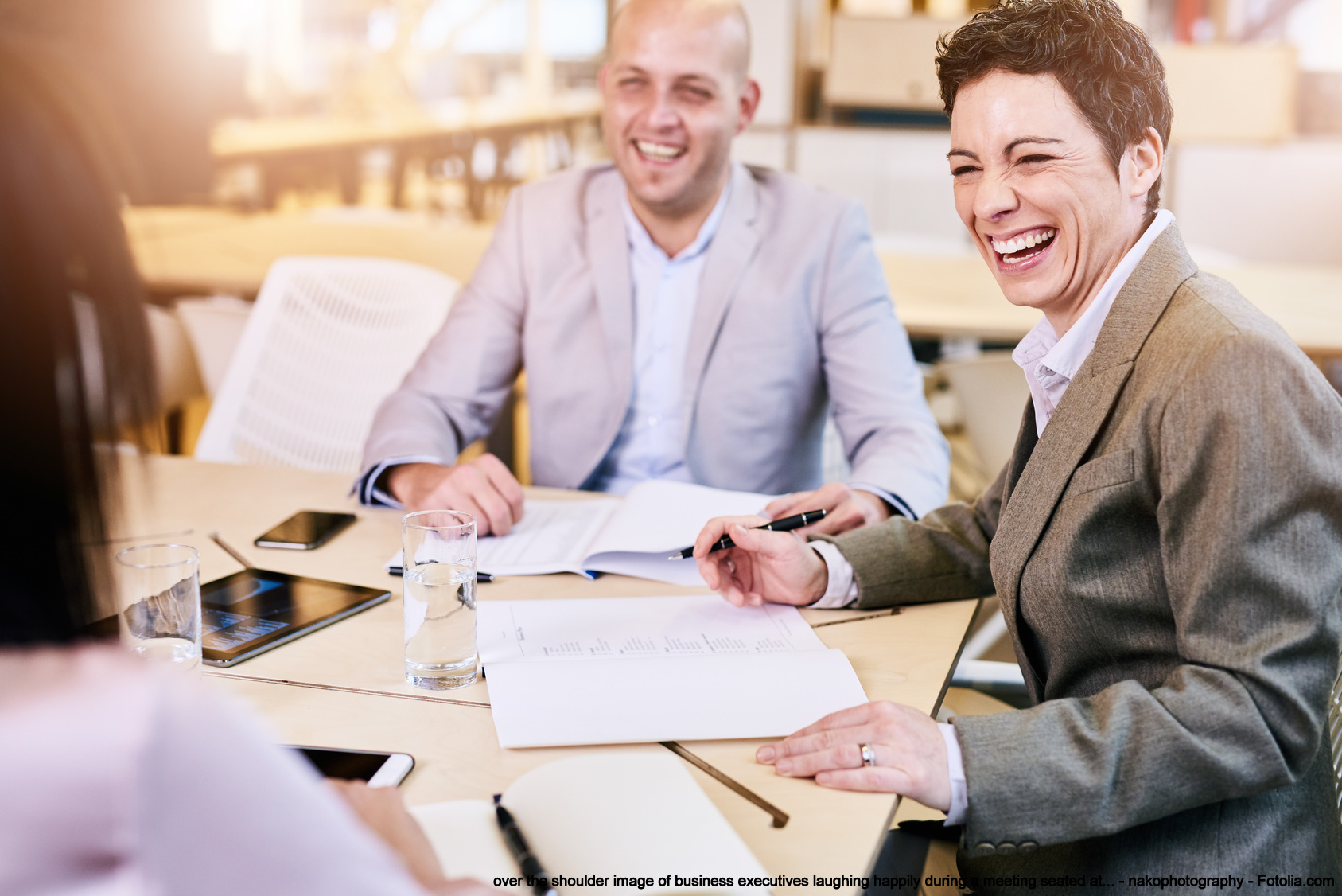 executives laughing happily during a meeting